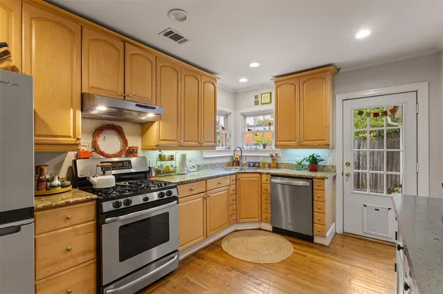 a kitchen with stainless steel appliances granite countertop a stove a sink and a microwave