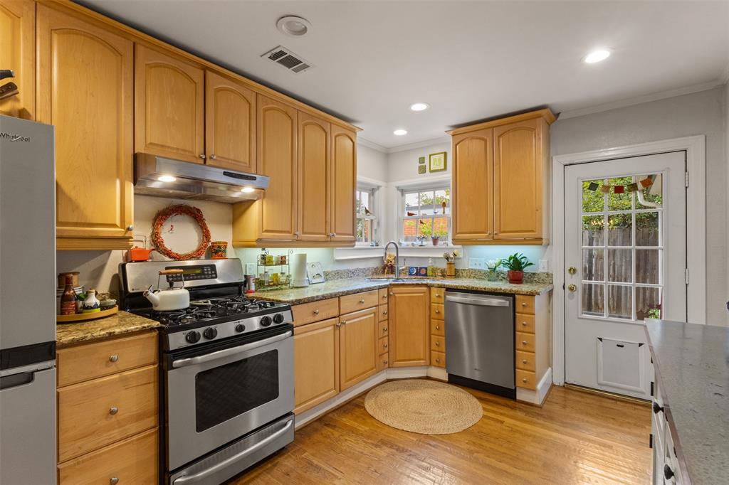 9461 Waterview Road Dallas, TX 75218 - Photo 12 of 40 a kitchen with stainless steel appliances granite countertop a stove a sink and a microwave