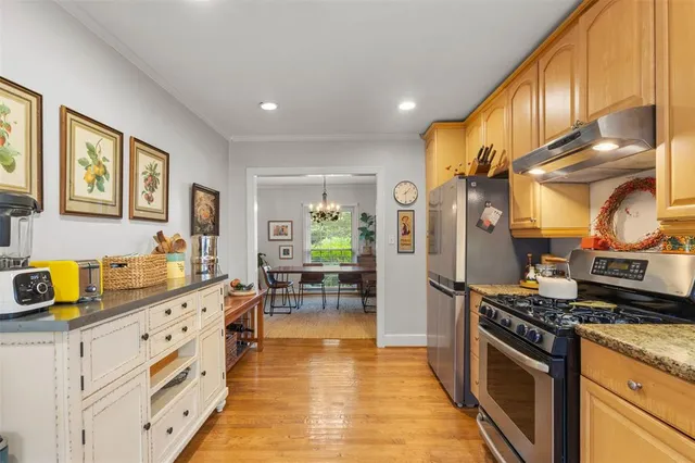 a kitchen with stainless steel appliances granite countertop a stove a sink and a refrigerator