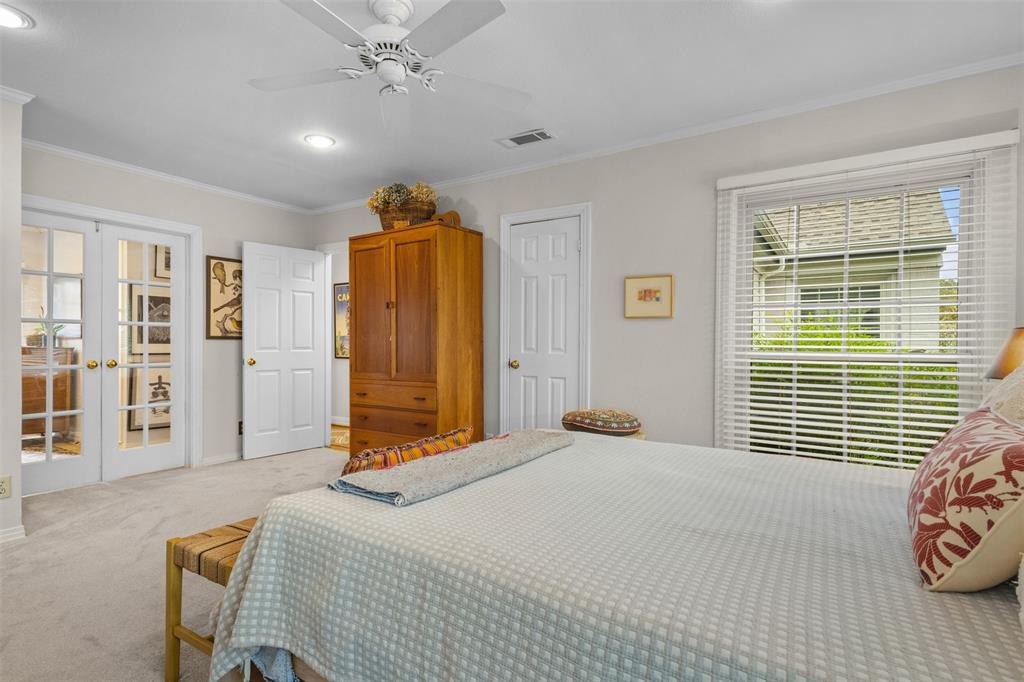 9461 Waterview Road Dallas, TX 75218 - Photo 22 of 40 a bedroom with a bed and a chandelier