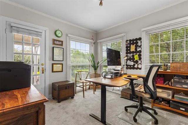 a view of a workspace with furniture and a window