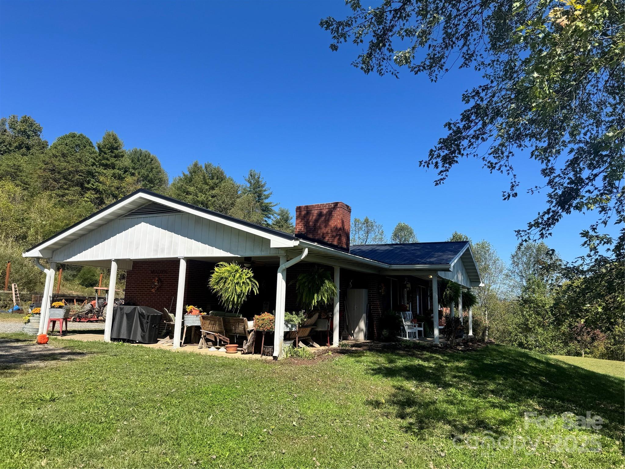 32 Bud Swann Road Marshall, NC 28753 - Photo 2 of 48 a patio with a table and chairs under an umbrella