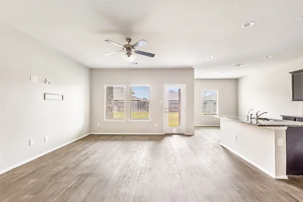 a view of a big room with wooden floor and windows