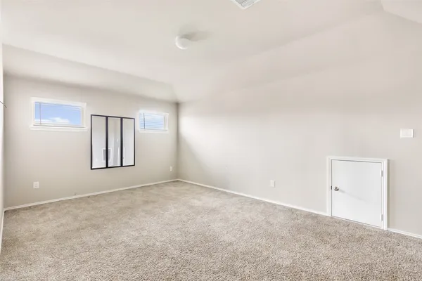 an empty room with windows and cabinet