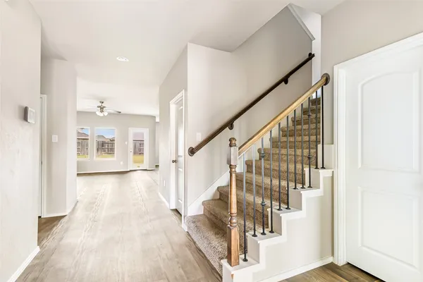 a view of a hallway with wooden floor and staircase