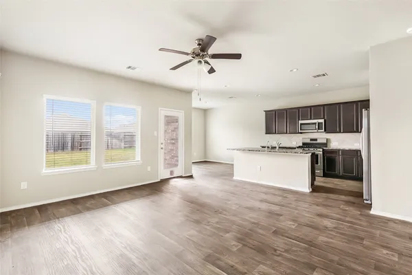 a view of open kitchen with granite countertop cabinets and window