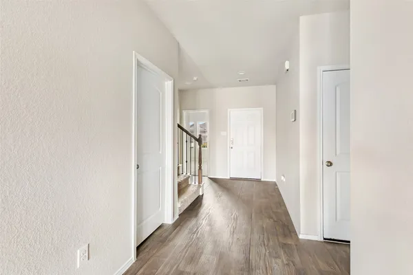 a view of a hallway with wooden floor