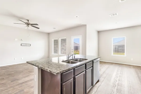 a kitchen with granite countertop kitchen island a sink appliances and a large window