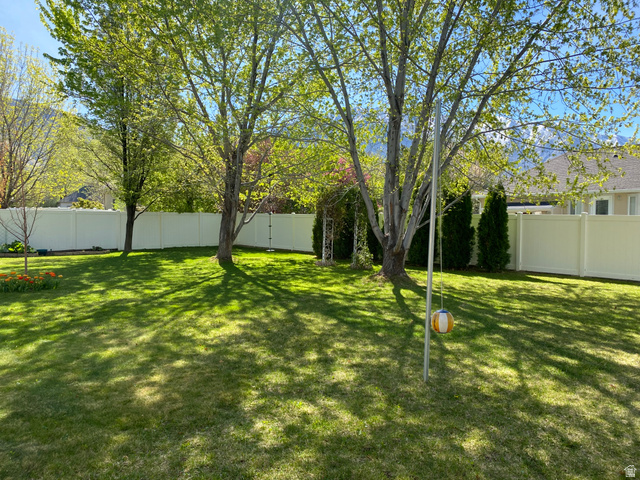 1976 River Bottom Road Springville, UT 84663 - Photo 4 of 45 Expansive lawn area featuring mature trees and a vinyl privacy fence