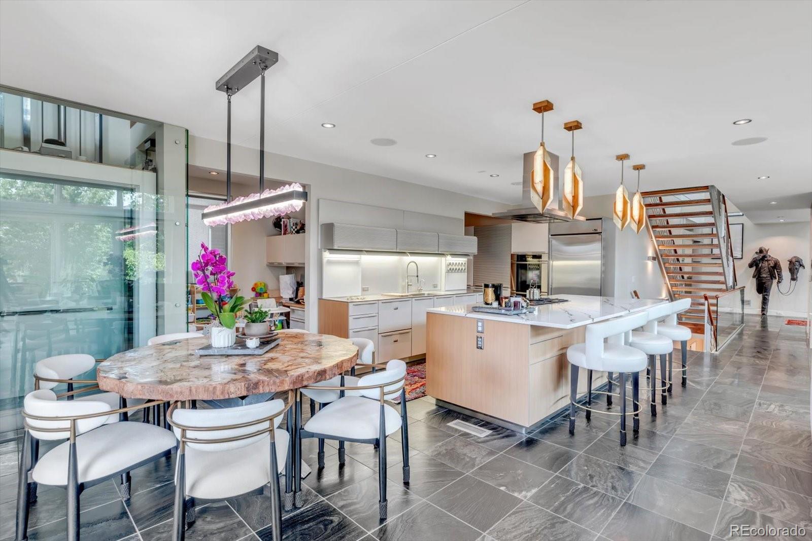 301 Monroe Street Denver, CO 80206 - Photo 14 of 44 a kitchen with a dining table chairs and white cabinets