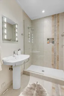 a bathroom with a sink shower and a mirror