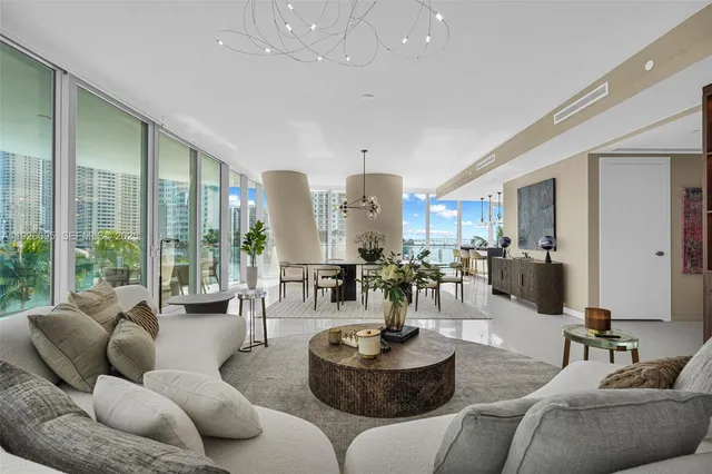 a dining room with furniture water view and a floor to ceiling window