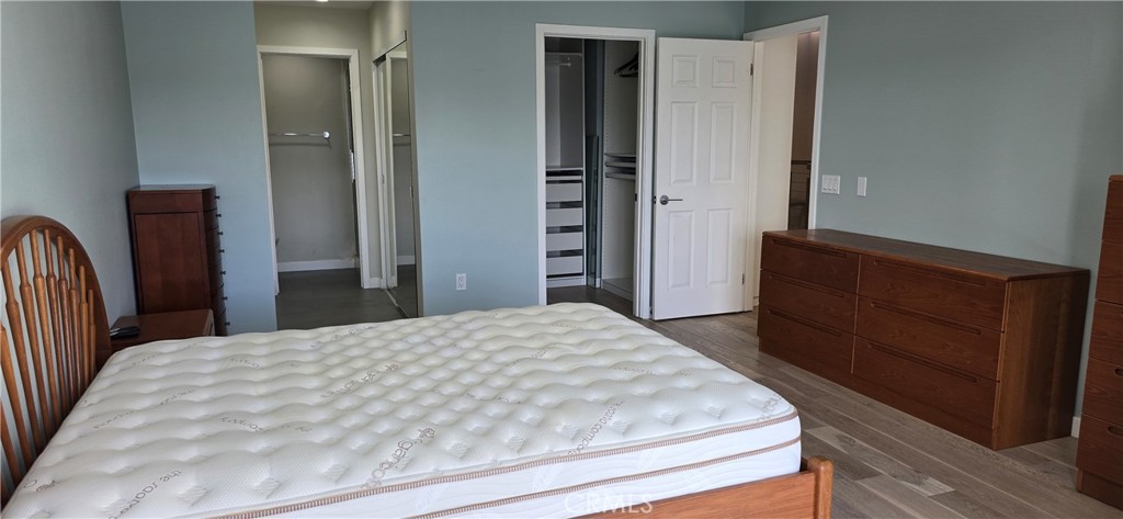 5224 Walnut Avenue, Unit 8 Irvine, CA 92618 - Photo 10 of 14 a bedroom with a bed and wooden floor