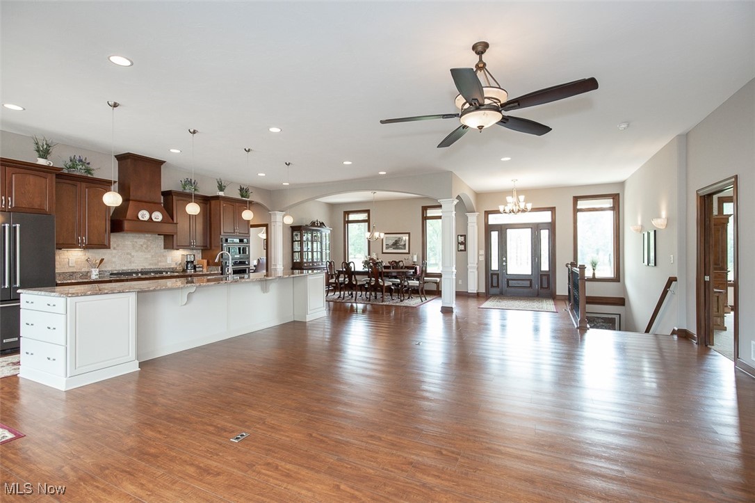 9155 Shank Road Litchfield, OH 44253 - Photo 46 of 47 Kitchen with open floor plan, decorative columns, a kitchen breakfast bar, arched walkways, and decorative backsplash