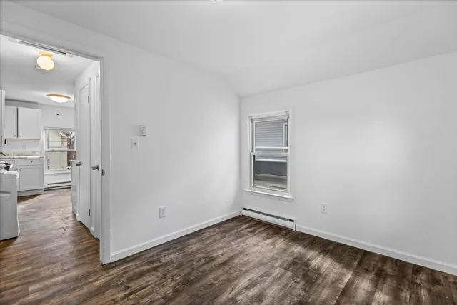 a view of a kitchen with wooden floor and a window