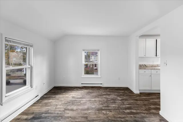 a view of a livingroom with wooden floor and a window