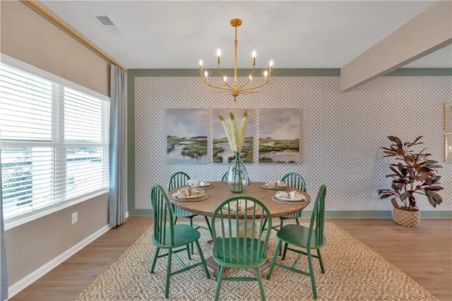 a view of a dining room with furniture a chandelier and wooden floor