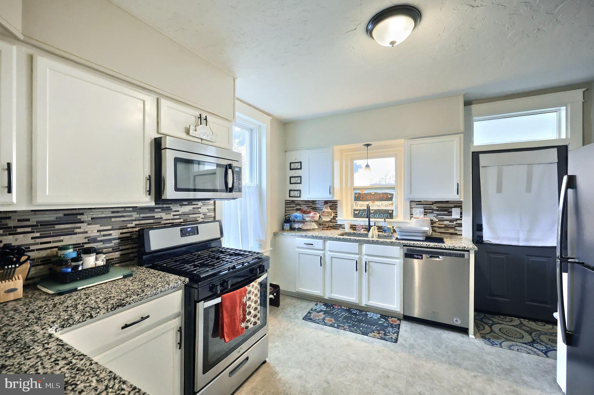 14 Gateway Road York, PA 17403 - Photo 5 of 35 a kitchen with stainless steel appliances granite countertop a stove top oven a sink dishwasher a refrigerator and a microwave