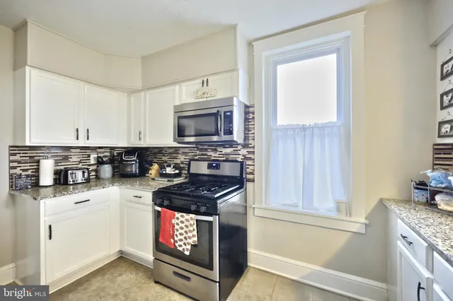 a kitchen with a sink a refrigerator and cabinets