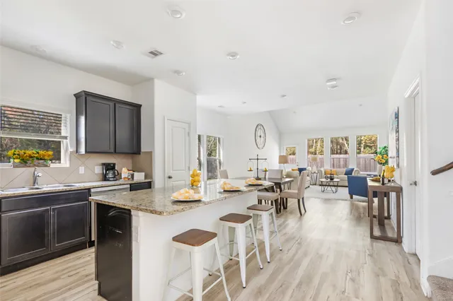 a kitchen with kitchen island wooden floors white appliances and cabinets
