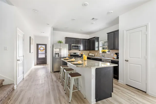 a kitchen with stainless steel appliances granite countertop a sink stove and cabinets