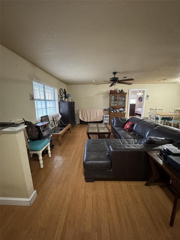 636 East Kempner Street Mabank, TX 75147 - Photo 23 of 28 Living area featuring wood-finish flooring, a window with horizontal blinds, and a ceiling fan