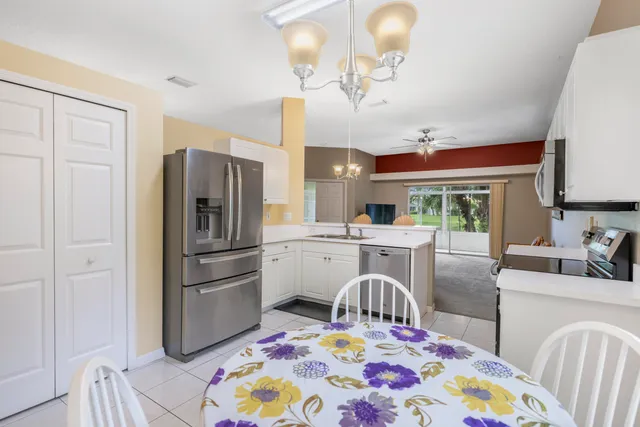 a kitchen with kitchen island a appliances dining table and chairs
