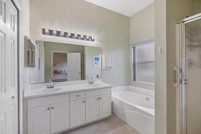 a bathroom with a tub a sink and mirror