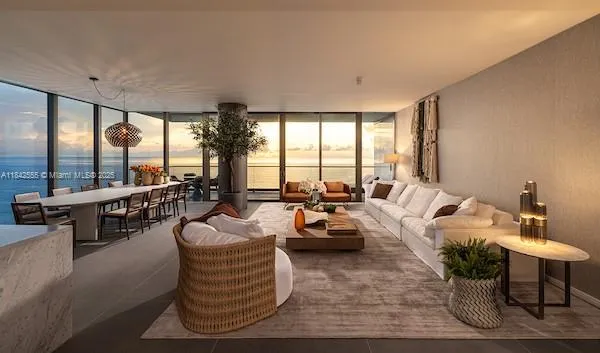 a living room with furniture and floor to ceiling windows