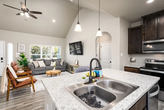 a kitchen with a sink a counter space appliances and cabinets