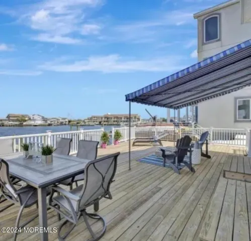 a view of a roof deck with table and chairs and wooden floor
