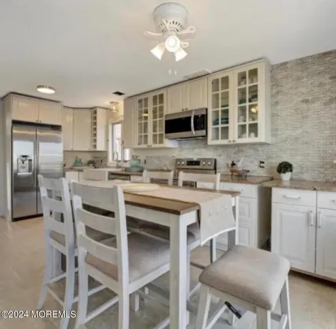 a kitchen with a dining table chairs appliances and cabinets