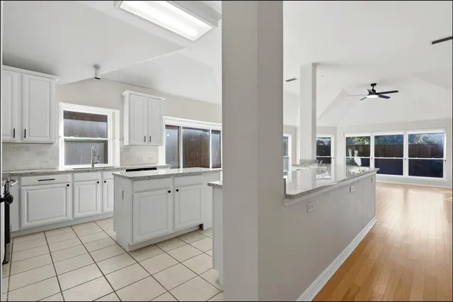 a kitchen with cabinets and wooden floor