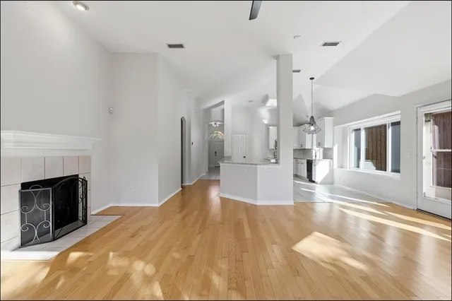 a view of empty room with wooden floor and fireplace