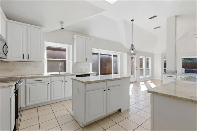 a kitchen with white cabinets appliances and a sink
