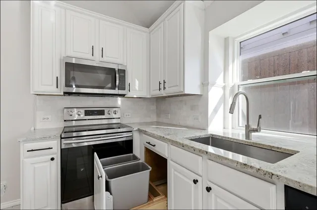 a kitchen with granite countertop a sink and steel appliances