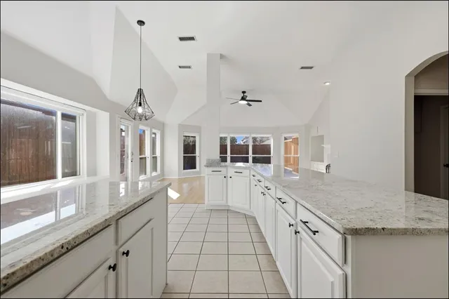 a large white kitchen with granite countertop a sink