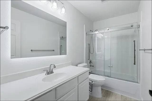 a bathroom with a sink a toilet and shower