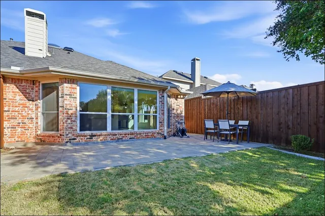 a view of a house with backyard and sitting area