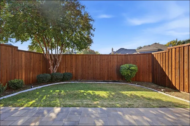 a view of an backyard with plants and wooden fence
