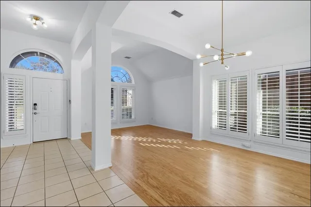 a view of an empty room with window and cabinet