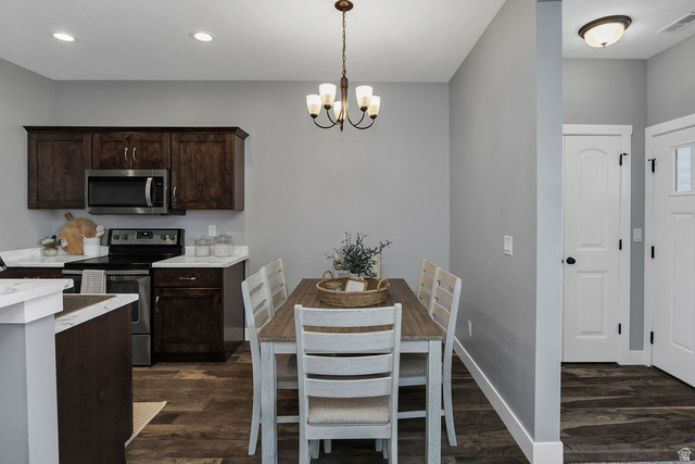 2483 South 1296th Street West Logan, UT 84321 - Photo 7 of 45 Open-concept dining area featuring a bronze chandelier, wood-finish flooring, and white baseboards