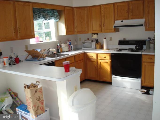 6149 Good Hunters Ride Columbia, MD 21045 - Photo 9 of 30 a kitchen with stainless steel appliances granite countertop a sink dishwasher a stove a refrigerator and cabinets with wooden floor