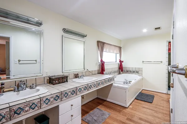 a spacious bathroom with a double vanity sink and a mirror