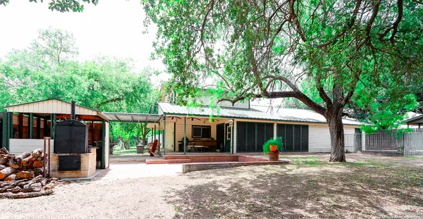 a view of a house with backyard and sitting area
