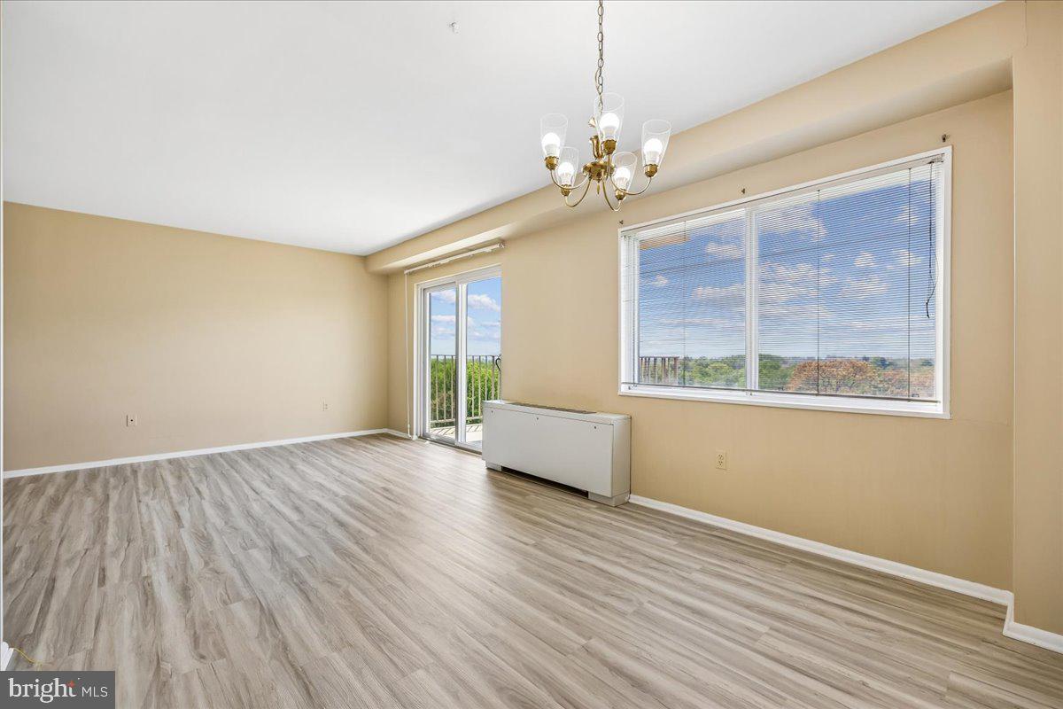 1111 University Boulevard West, Unit 1106A Silver Spring, MD 20902 - Photo 8 of 35 a view of an empty room with a window and wooden floor
