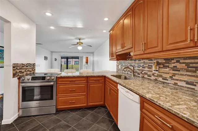 a kitchen with stainless steel appliances granite countertop a sink and cabinets
