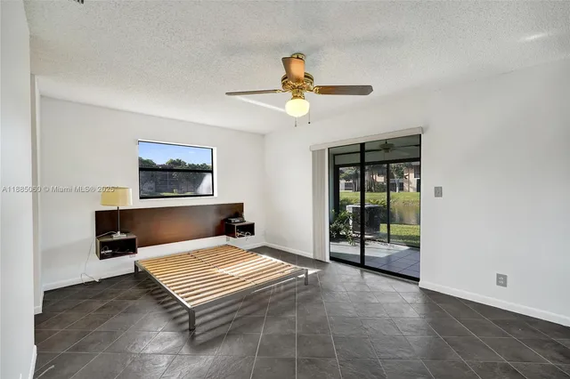 a living room with furniture flat screen tv and ceiling fan