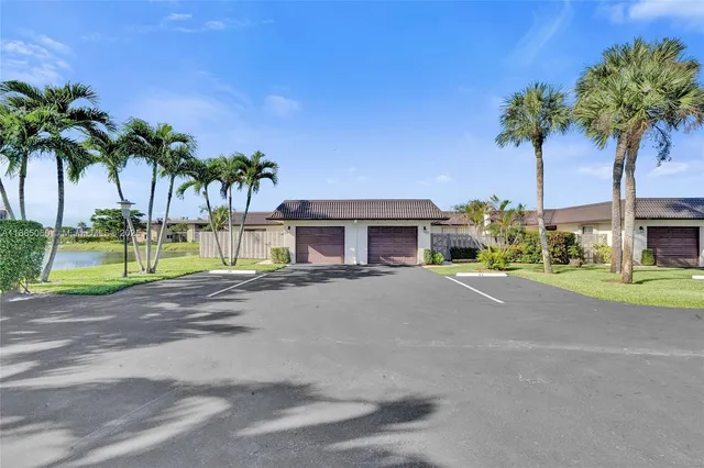 a palm tree sitting in front of a house with a yard