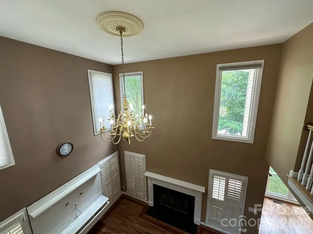 a view of hallway with chandelier and wooden floor